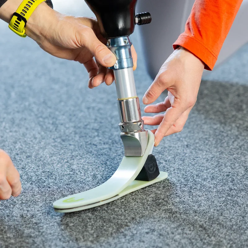 Mitarbeiter justiert einen Glasfaser-Prothesenfuß an einer Unterschenkelprothese – Anpassung und Feinabstimmung
