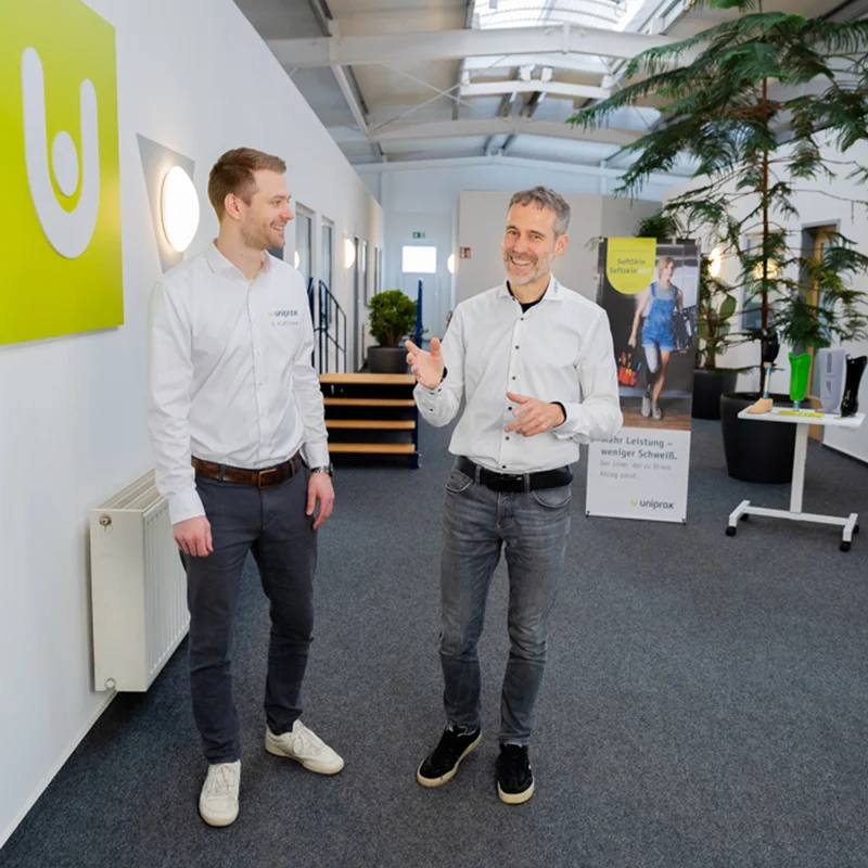 Zwei Uniprox Mitarbeiter im Gespräch im Unternehmen – Austausch, Teamarbeit und moderne Arbeitskultur im Arbeitsalltag